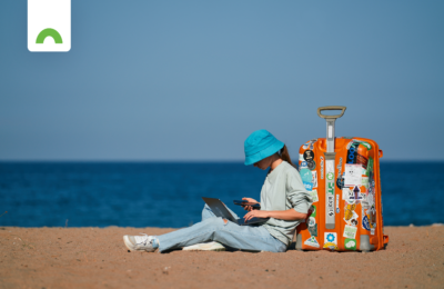 Lady working remotely on beach with suitcase