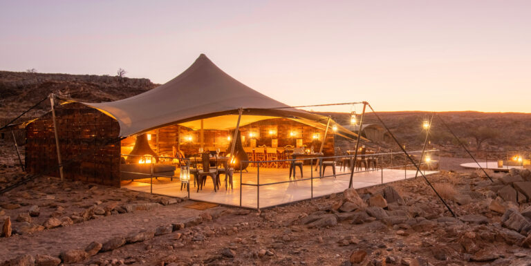Scenic drive from Etosha to Damaraland with a Magic Box picnic en route, ending with fireside sundowners at Camp Doros in Namibia’s remote desert landscapes.